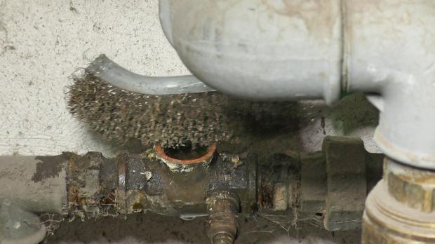 Wasserhahn mit Drahtbürste säubern