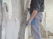 Verputzte Wand mit Richtscheit abziehen